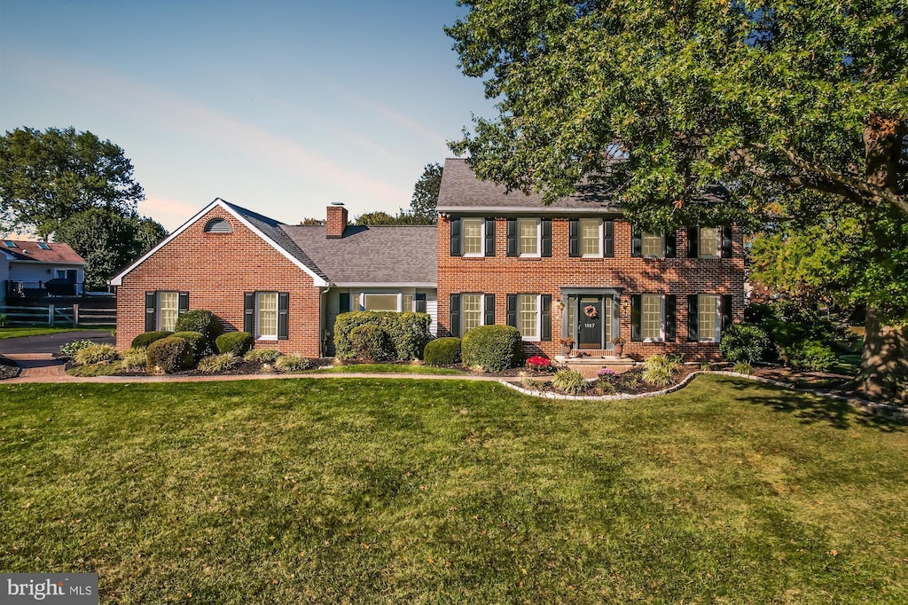 colonial inspired home with a yard