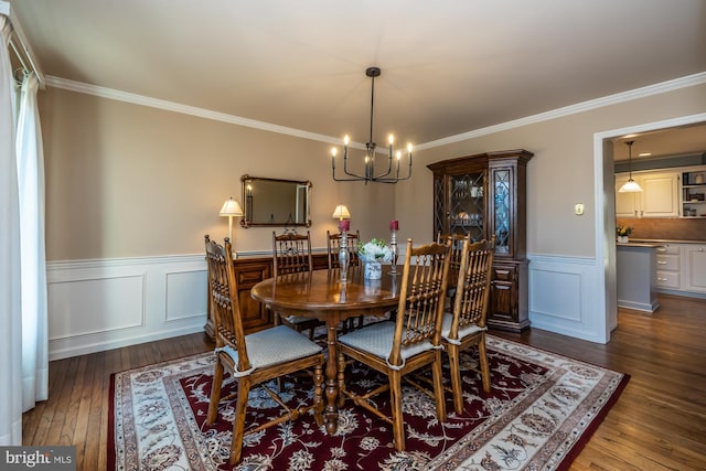 dining area featuring an inviting chandelier, hardwood / wood-style floors, and ornamental molding