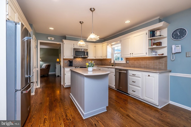 kitchen with a kitchen island, appliances with stainless steel finishes, tasteful backsplash, white cabinetry, and hanging light fixtures