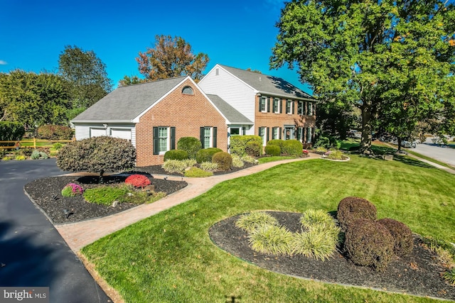 colonial-style house featuring a garage and a front yard