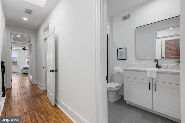 hall with dark hardwood / wood-style floors and a skylight