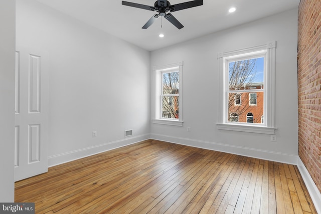 empty room with ceiling fan and hardwood / wood-style floors