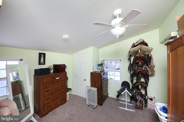 misc room featuring ceiling fan, light colored carpet, radiator, and a healthy amount of sunlight