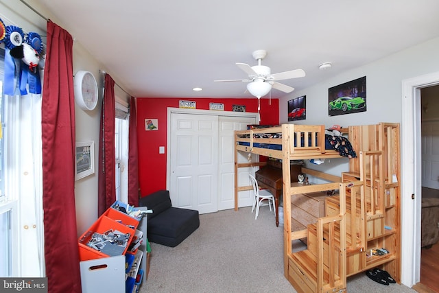 carpeted bedroom featuring a closet, lofted ceiling, and ceiling fan