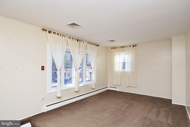 carpeted spare room with a baseboard heating unit