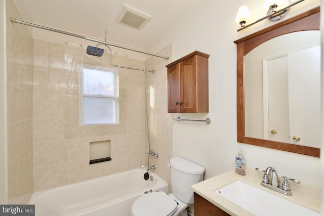 full bathroom with tiled shower / bath, vanity, and toilet