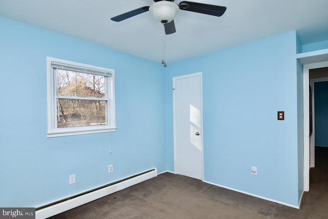 spare room with dark colored carpet, ceiling fan, and baseboard heating