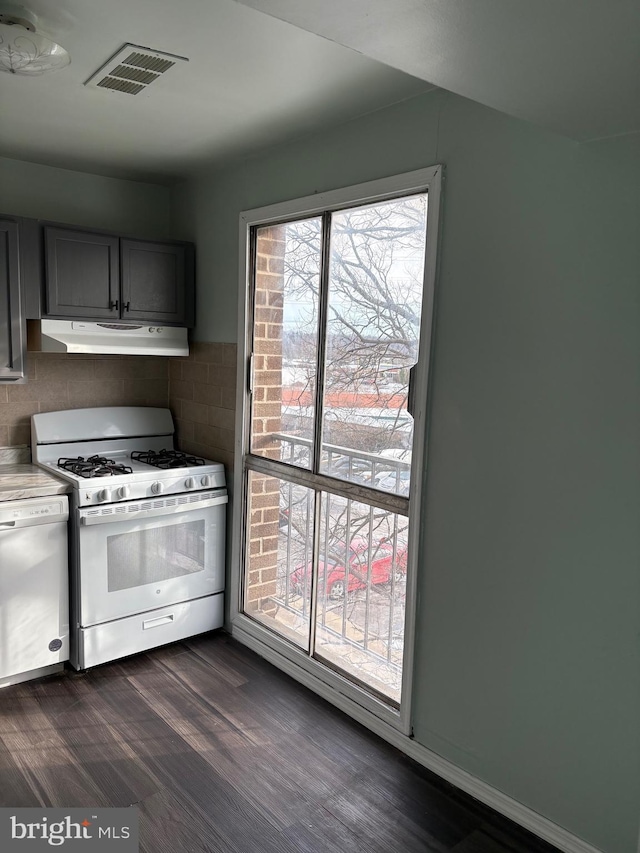 kitchen with white appliances, dark hardwood / wood-style flooring, decorative backsplash, and gray cabinetry