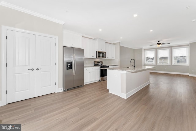 kitchen featuring white cabinets, appliances with stainless steel finishes, sink, ceiling fan, and a center island with sink