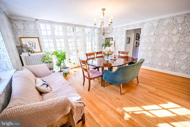 dining area with hardwood / wood-style flooring, a notable chandelier, and ornamental molding