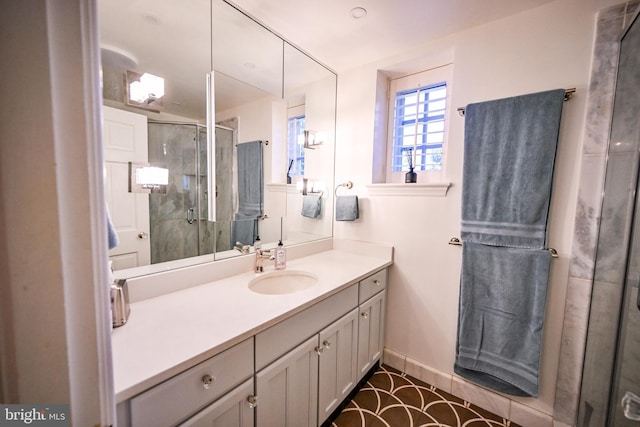 bathroom featuring a shower with door and vanity