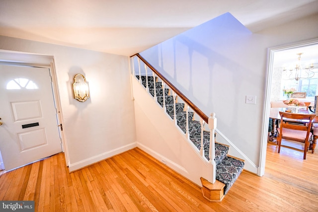 foyer entrance with a chandelier and light hardwood / wood-style floors