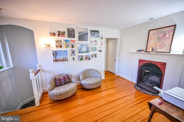 sitting room with hardwood / wood-style flooring and a fireplace