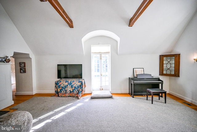 interior space with wood-type flooring and lofted ceiling with beams