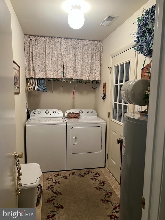 washroom featuring water heater and washing machine and clothes dryer