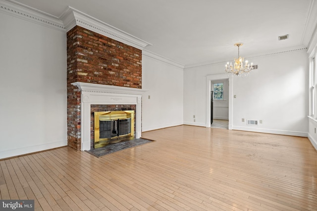 unfurnished living room with ornamental molding, a fireplace, and light hardwood / wood-style floors