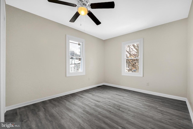 empty room with dark hardwood / wood-style floors, a wealth of natural light, and ceiling fan