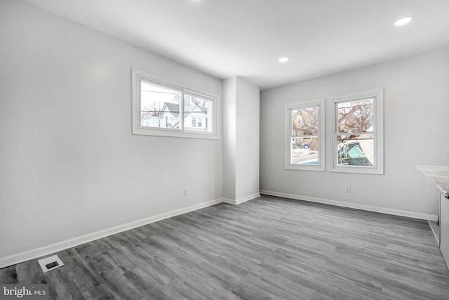 unfurnished room featuring a healthy amount of sunlight and hardwood / wood-style floors