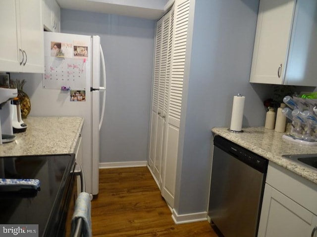 kitchen featuring white cabinetry, dark wood-type flooring, stainless steel dishwasher, and light stone counters