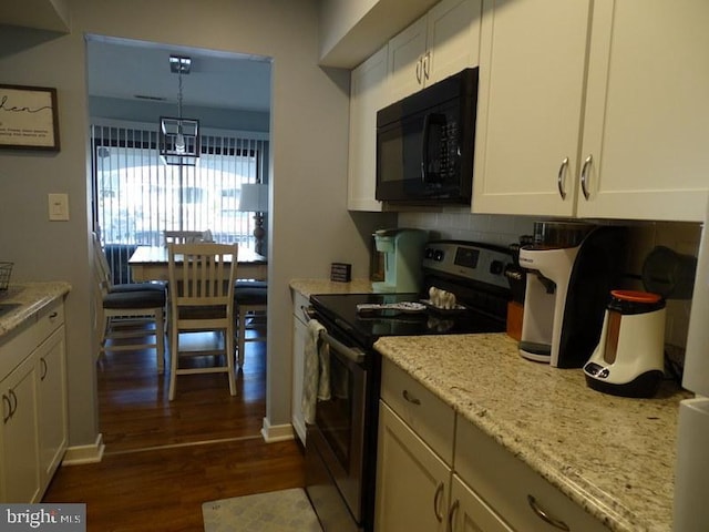 kitchen featuring dark wood-type flooring, light stone counters, white cabinets, stainless steel electric range oven, and decorative light fixtures