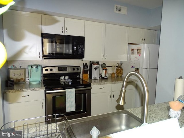 kitchen featuring white cabinetry, decorative backsplash, stainless steel electric range oven, and light stone counters