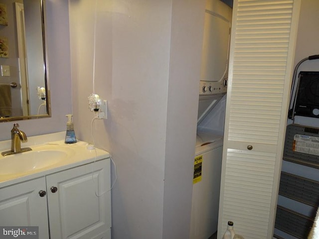 bathroom with stacked washer / dryer and vanity