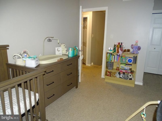 carpeted bedroom featuring a crib