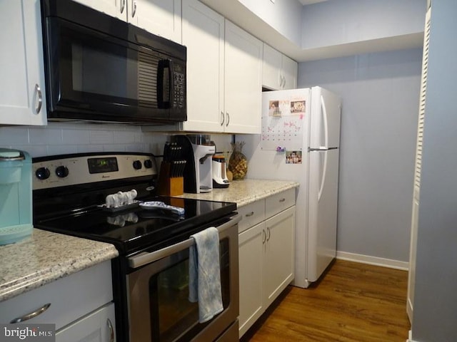 kitchen featuring stainless steel electric range oven, light stone countertops, and white cabinets