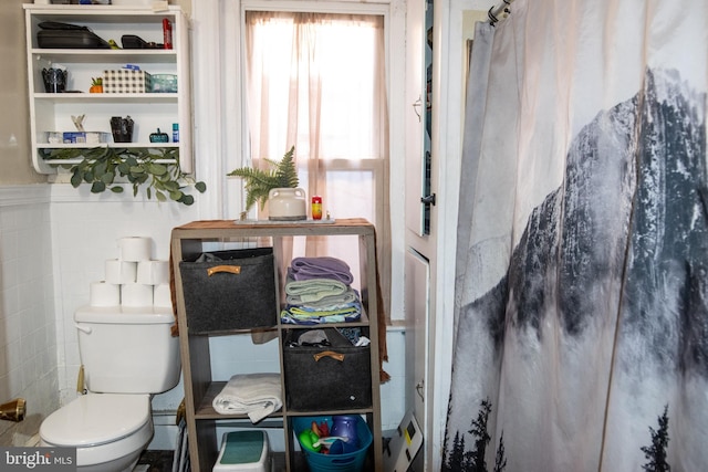 bathroom featuring a shower with curtain and toilet