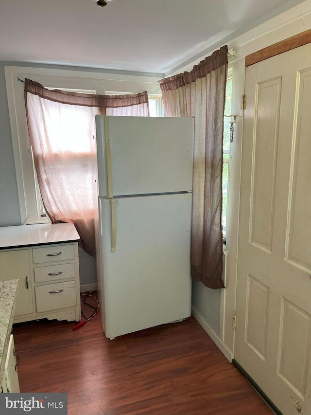 kitchen featuring dark wood-type flooring, white cabinets, and white fridge