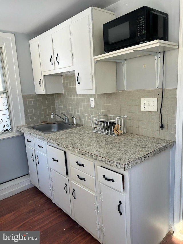 kitchen with sink, dark wood-type flooring, white cabinetry, and decorative backsplash