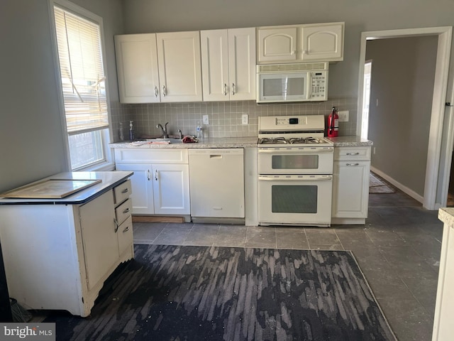 kitchen with sink, white appliances, white cabinetry, and tasteful backsplash