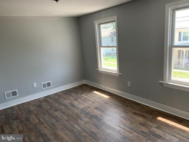 empty room with dark hardwood / wood-style flooring