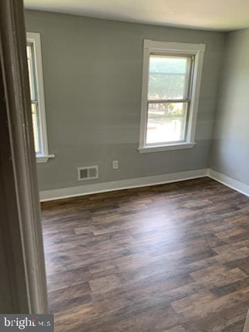 spare room with dark wood-type flooring