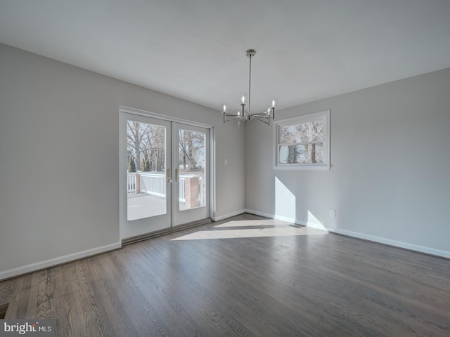 unfurnished dining area with hardwood / wood-style flooring, french doors, and a notable chandelier