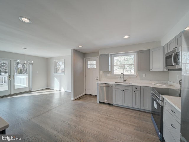 kitchen featuring stainless steel appliances, gray cabinets, and sink