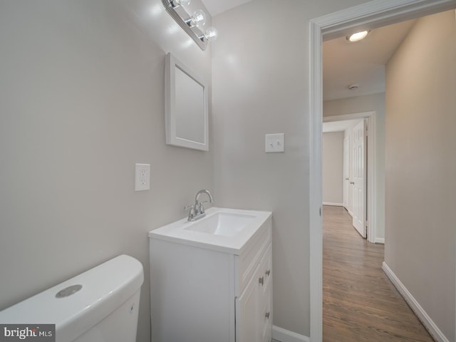 bathroom with vanity, hardwood / wood-style floors, and toilet