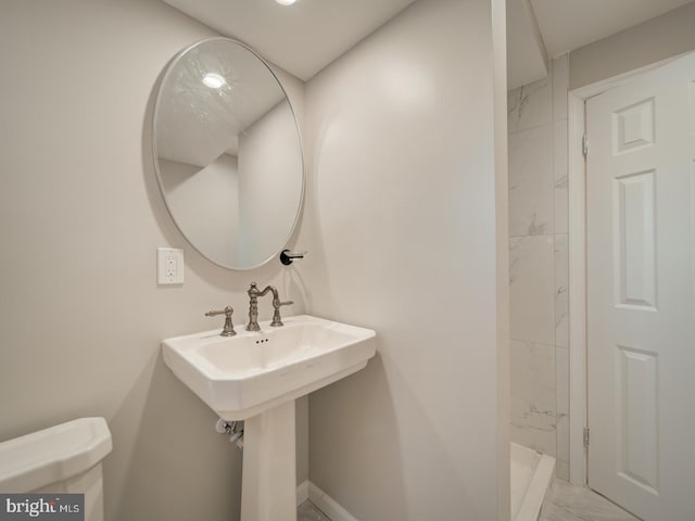 bathroom with tiled shower and toilet