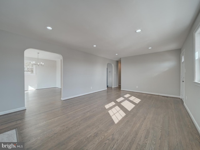 empty room featuring hardwood / wood-style floors and a chandelier