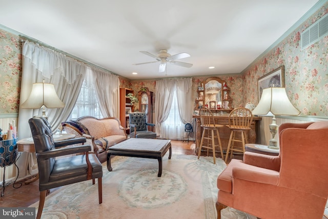 sitting room featuring bar, a healthy amount of sunlight, hardwood / wood-style floors, and ceiling fan