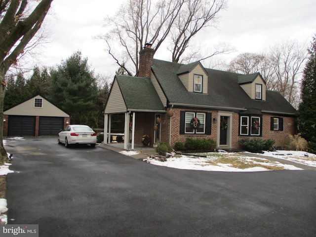 cape cod home with a garage and an outbuilding