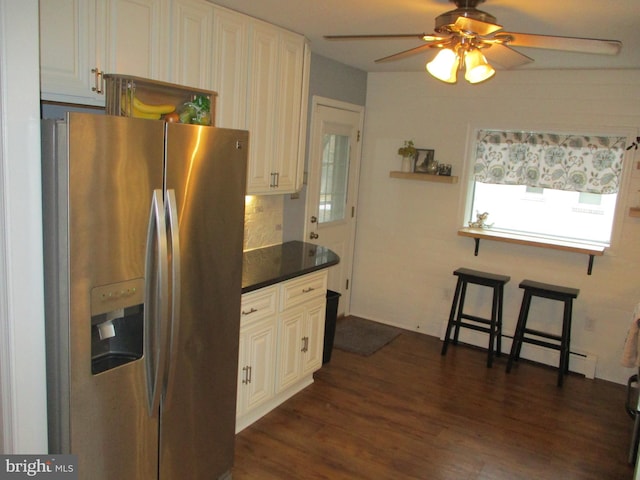 kitchen featuring stainless steel refrigerator with ice dispenser, ceiling fan, tasteful backsplash, a baseboard radiator, and dark wood-type flooring