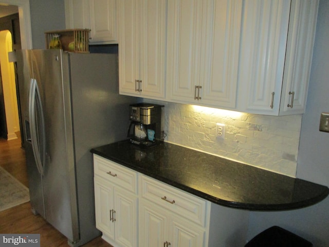 kitchen featuring dark wood-type flooring, white cabinetry, stainless steel fridge, and tasteful backsplash