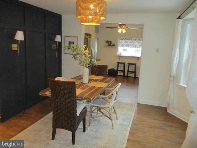 dining area with hardwood / wood-style flooring, baseboard heating, and ceiling fan