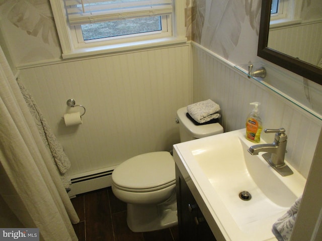 bathroom featuring hardwood / wood-style flooring, a baseboard radiator, toilet, and vanity