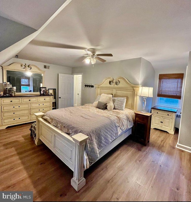 bedroom with ceiling fan, dark hardwood / wood-style floors, and lofted ceiling