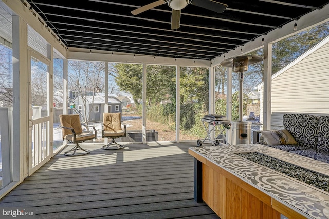 sunroom / solarium featuring ceiling fan