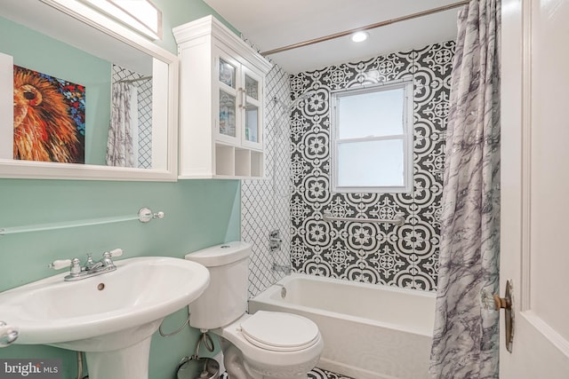 full bathroom featuring sink, toilet, and shower / bathtub combination with curtain