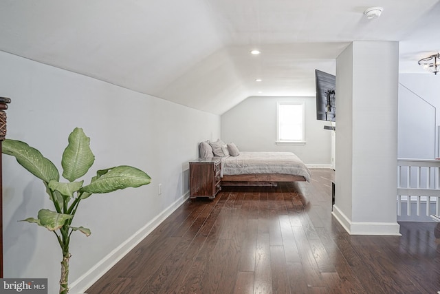 bedroom with vaulted ceiling and dark hardwood / wood-style flooring