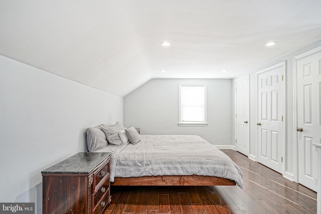 bedroom with dark wood-type flooring and vaulted ceiling